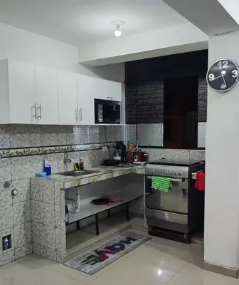 a kitchen with white cabinets and a sink and a stove at Apartment 10 minutes from the airport in Lima