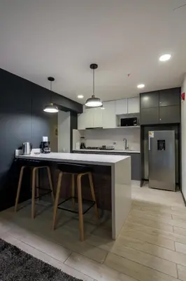 a kitchen with a large island with two stools at Pionero by geko in Lima