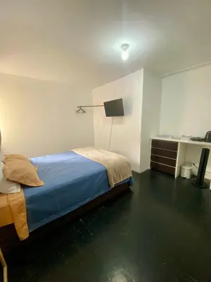 a bedroom with a bed and a desk at Habitaciones Independientes Av Larco in Lima