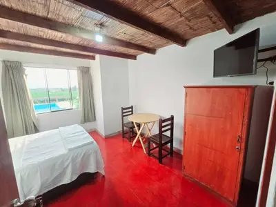 a bedroom with a bed and a table and a tv at Los Angeles Hotel in Huaral