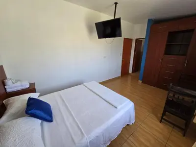 a bedroom with a bed with a blue pillow on it at Los Angeles Hotel in Huaral