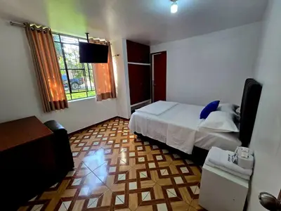 a bedroom with a bed and a television in it at Los Angeles Hotel in Huaral