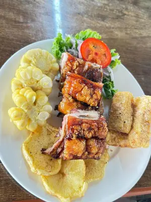 a plate of food with meat and vegetables on a table at Los Angeles Hotel in Huaral