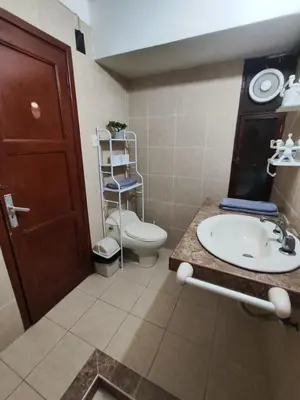 a bathroom with a toilet and a sink and a mirror at Amplia habitación dos camas dobles Miraflores in Lima