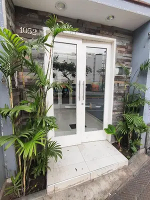 a white door with plants in front of a building at Céntrica habitación con vistas Miraflores in Lima