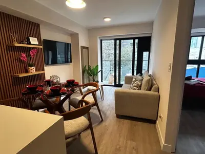 a living room with a dining room table and a couch at Brand new apartment in Miraflores in Lima