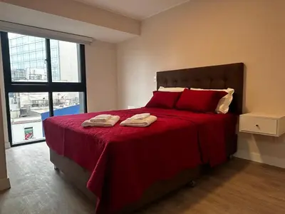 a bedroom with a red bed with two towels on it at Brand new apartment in Miraflores in Lima