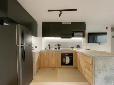 a kitchen with green cabinets and a stainless steel refrigerator at Barranco Breeze Loft Apartments by Geko in Lima