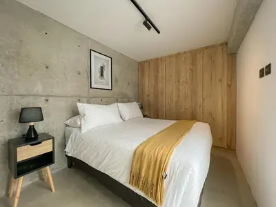 a bedroom with a bed and a table with a lamp at Barranco Breeze Loft Apartments by Geko in Lima
