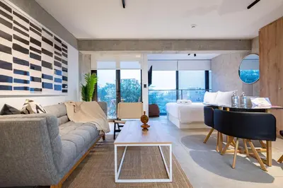a living room with a couch and a bed and a table at Barranco Breeze Loft Apartments by Geko in Lima