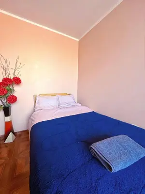 a bedroom with a bed with a blue blanket and flowers at Departamento completo cerca de la Plaza ,cocina equipada y vista a la ciudad in Ayacucho