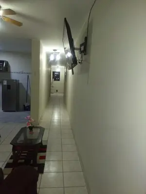 a hallway with a table and a light on a wall at Angelica's House - Apartments Lima - Near the Airport in Lima