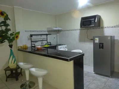 a kitchen with a counter and a refrigerator and a microwave at Angelica's House - Apartments Lima - Near the Airport in Lima