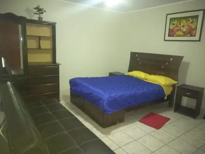 a bedroom with a bed with a blue comforter and yellow sheets at Angelica's House - Apartments Lima - Near the Airport in Lima