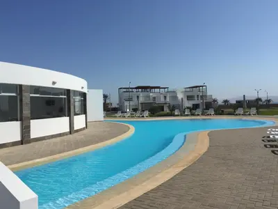 a swimming pool in front of a building at Paracas Beach Vacation Rentals in Paracas