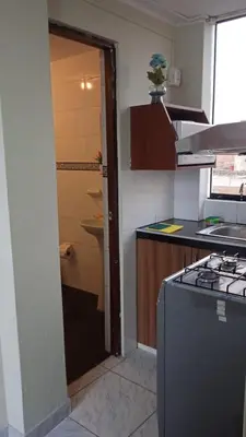 a kitchen with a stove and a door to a sink at Studio with kitchen and Bathroom Near The Airport in Lima