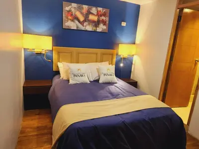 a bedroom with a large bed with blue walls at Hotel Panaka II in Cusco