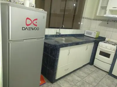 a kitchen with a white refrigerator and a sink at New Apartment furnished in Lima - Near the Airport in Lima