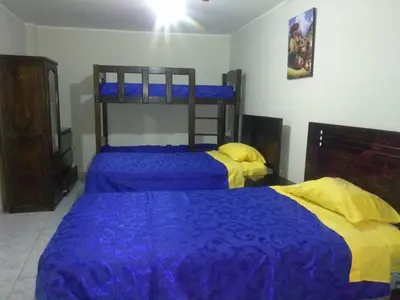 two beds with blue and yellow covers in a bedroom at New Apartment furnished in Lima - Near the Airport in Lima