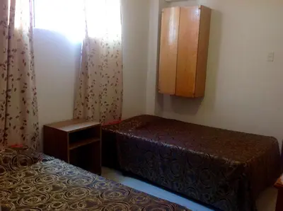 a small bedroom with two beds and a window at Hotel Estación Central in Lima