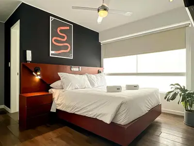 a bedroom with a large bed with a black wall at The Snake 1BR by Geko in Lima
