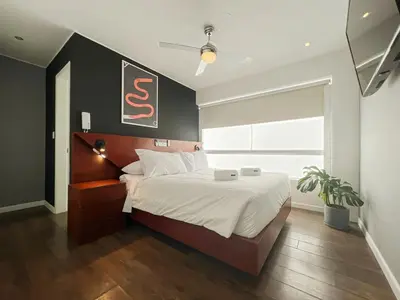a bedroom with a large bed and a large window at The Snake 1BR by Geko in Lima