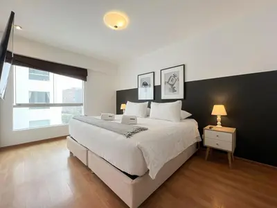a bedroom with a large white bed and a window at Barranco Sailor Apartment by Geko in Lima