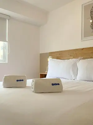 a white bed with two pillows on top of it at The Bird 2BR by Geko in Lima