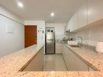 a kitchen with white cabinets and a stainless steel refrigerator at The Bird 2BR by Geko in Lima