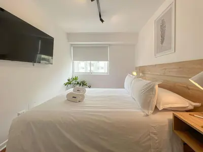 a bedroom with a white bed with a teddy bear on it at The Bird 2BR by Geko in Lima