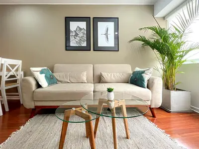 a living room with a couch and a glass table at The Bird 2BR by Geko in Lima