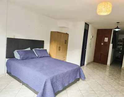 a bedroom with a bed with a purple blanket at Casa Porta in Lima