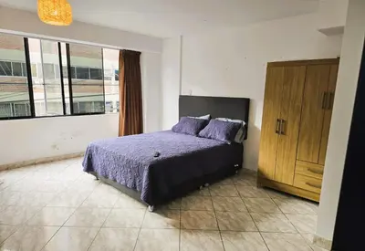 a bedroom with a purple bed and a wooden cabinet at Casa Porta in Lima
