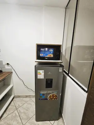 a small refrigerator with a microwave on top of it at Casa Porta in Lima