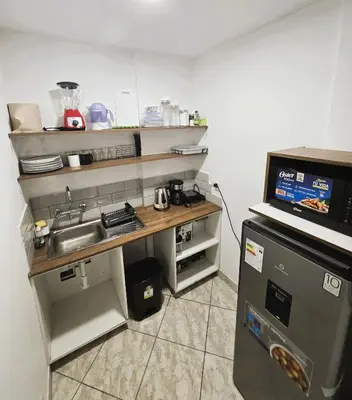 a small kitchen with a sink and a refrigerator at Casa Porta in Lima