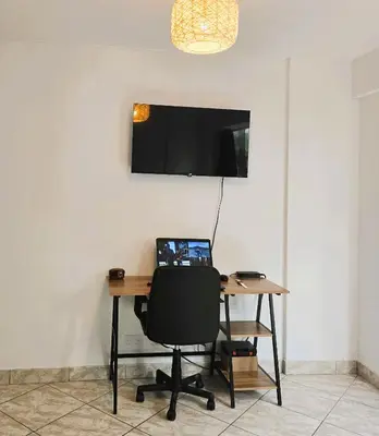 a desk with a laptop and a chair in a room at Casa Porta in Lima