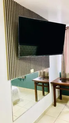 two tables in a room with a large television on the wall at Hostal Skyblue in Asia