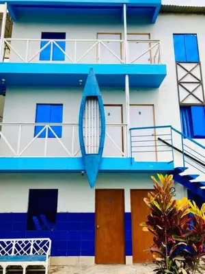 a blue and white building with a surfboard on it at Hostal Skyblue in Asia