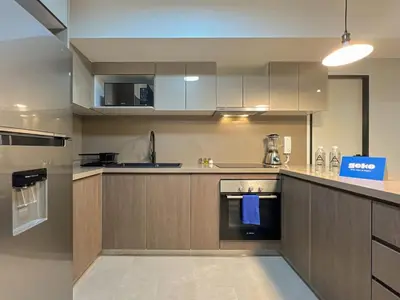 a large kitchen with wooden cabinets and appliances at Rivera Navarrete by Geko in Lima