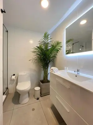 a bathroom with a toilet and a sink and a plant at Wood House 3BR by Geko in Lima