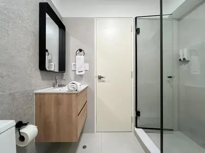 a bathroom with a shower and a sink and a mirror at Syberia 2BR by Geko in Lima