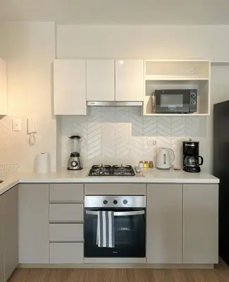 a kitchen with white cabinets and a stove top oven at Syberia 2BR by Geko in Lima