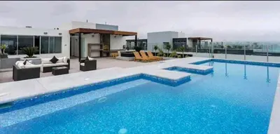 a large blue swimming pool on top of a building at Departamento amoblado vacacional in Lima