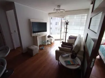a living room with a couch and a tv at Departamento amoblado vacacional in Lima