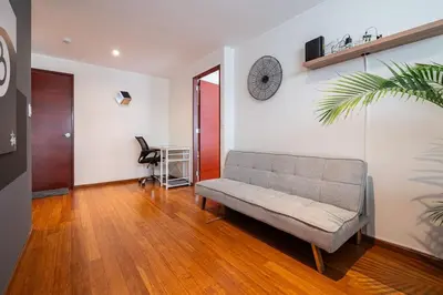 a living room with a couch and a clock on the wall at Taurus 2BR by Geko in Lima