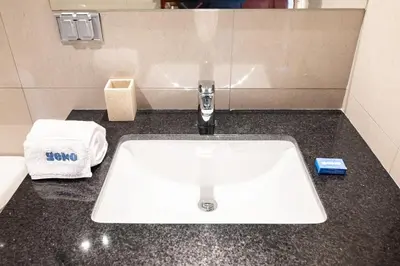 a bathroom counter with a white sink and towels at Taurus 2BR by Geko in Lima