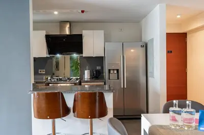 a kitchen with a stainless steel refrigerator and bar at Taurus 2BR by Geko in Lima