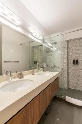 a bathroom with a sink and a glass shower at Premium 2BR Apartment Steps from Kennedy Park in Lima