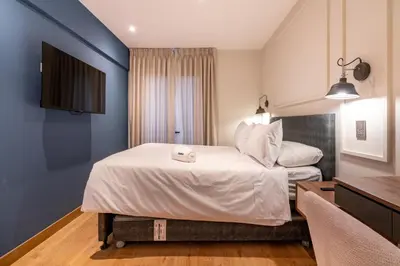 a hotel room with a bed and a desk at Premium 2BR Apartment Steps from Kennedy Park in Lima