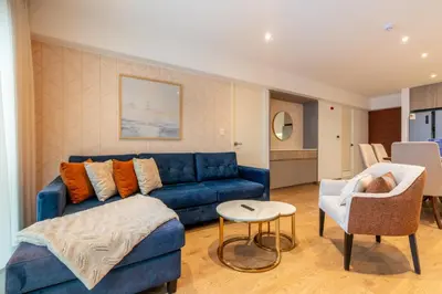 a living room with a blue couch and a table at Premium 2BR Apartment Steps from Kennedy Park in Lima